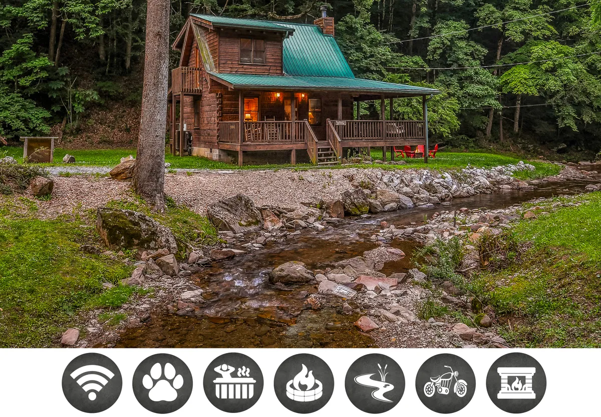 The hero image showcases a classic log cabin with a striking green metal roof, nestled among lush trees on the banks of a gentle creek. A spacious wooden porch overlooks the water, inviting guests to relax and soak in serene sunrise views. The tranquil setting is complemented by the promise of outdoor activities such as fishing, hiking, and evenings gathered around a cozy campfire.